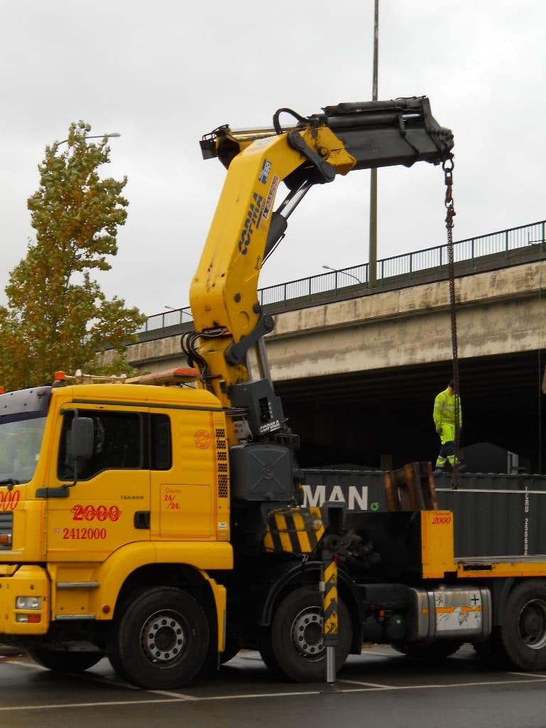 Voertuig wordt met de laadkraan precies op een container geplaatst